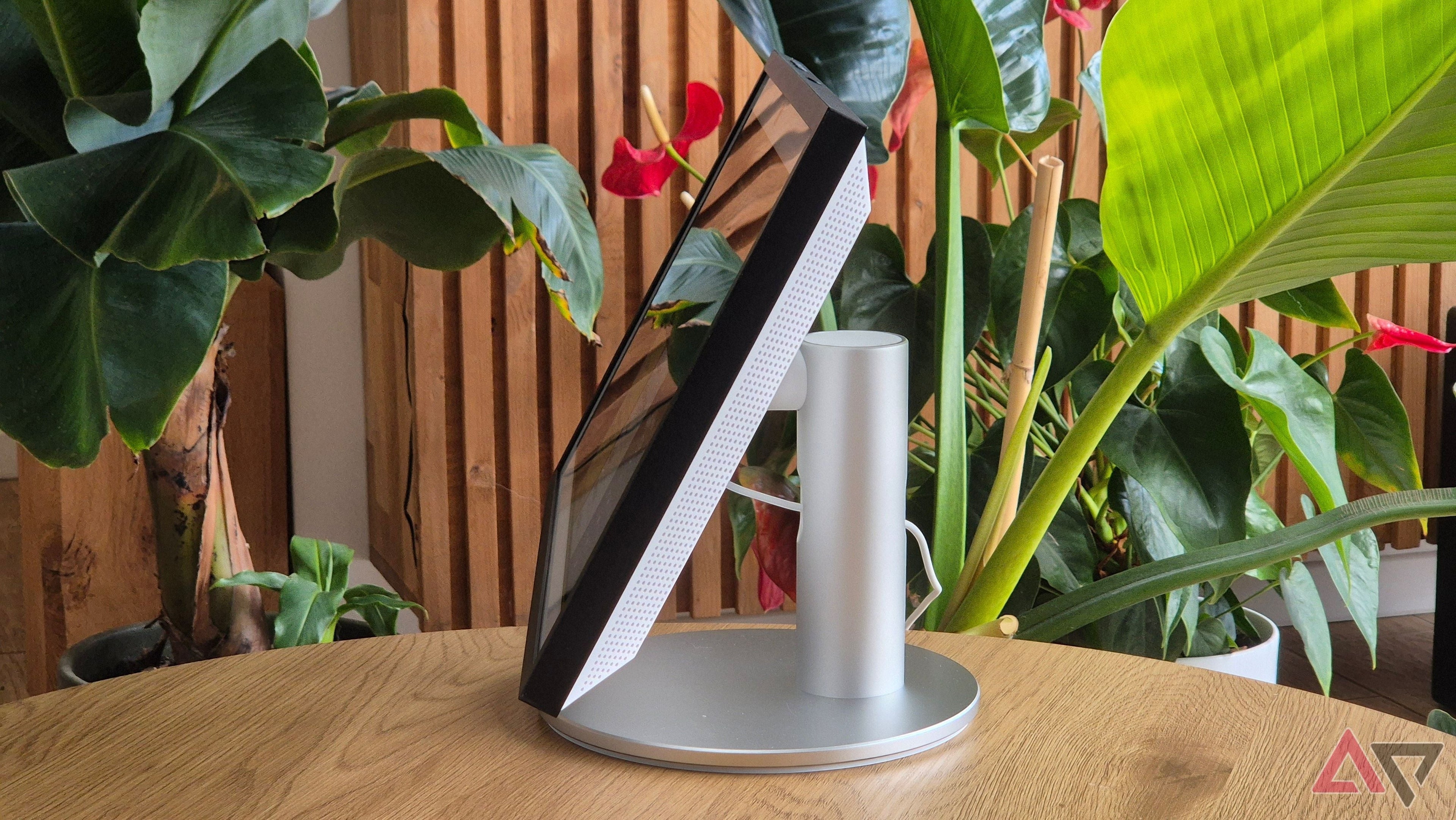 Tasty Tech Amazon Echo Show 15 (2nd Gen) smart display with a 15.6" Full HD screen and silver stand, set against lush greenery.